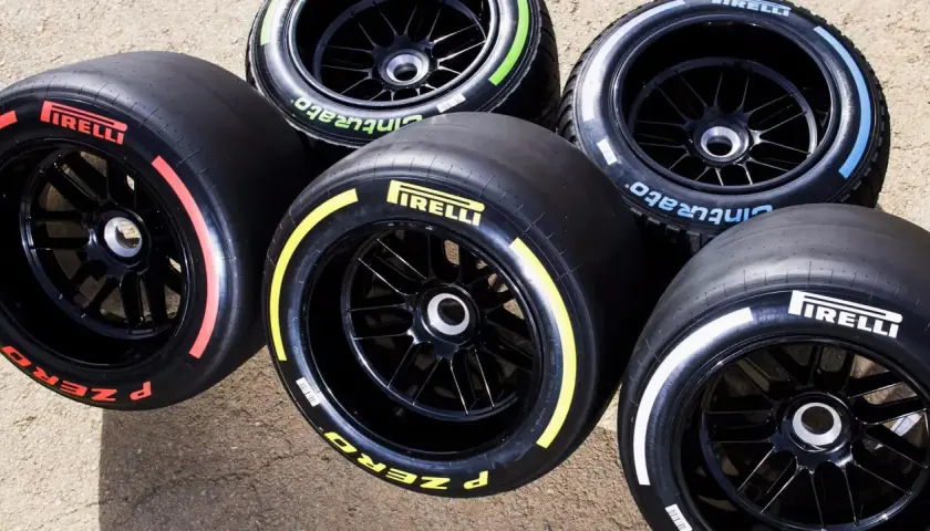 Pięć opon Pirelli F1 z kolorowymi paskami na bokach: czerwonym, żółtym, niebieskim, zielonym i białym.