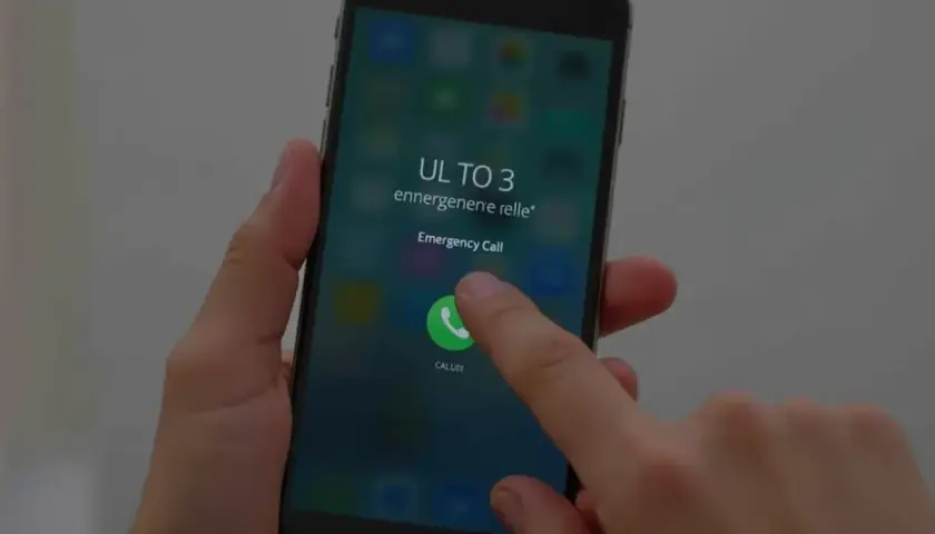Palec dotyka ikony połączenia alarmowego na ekranie telefonu, pokazując, jak odblokować telefon przez połączenie alarmowe w sytuacji awaryjnej.