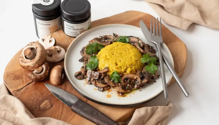 Veganes Pilzgericht mit gelbem Reis, garniert mit Koriander. Perfekt für Pilz Rezepte vegan.