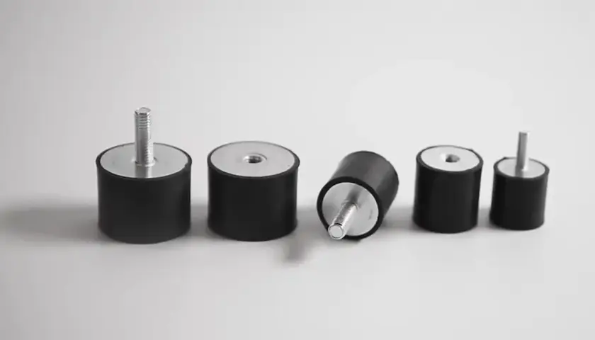 Cinco silentblocks de coche, algunos con tornillo, otros con rosca. Un silentblock roto, listo para ser reemplazado.