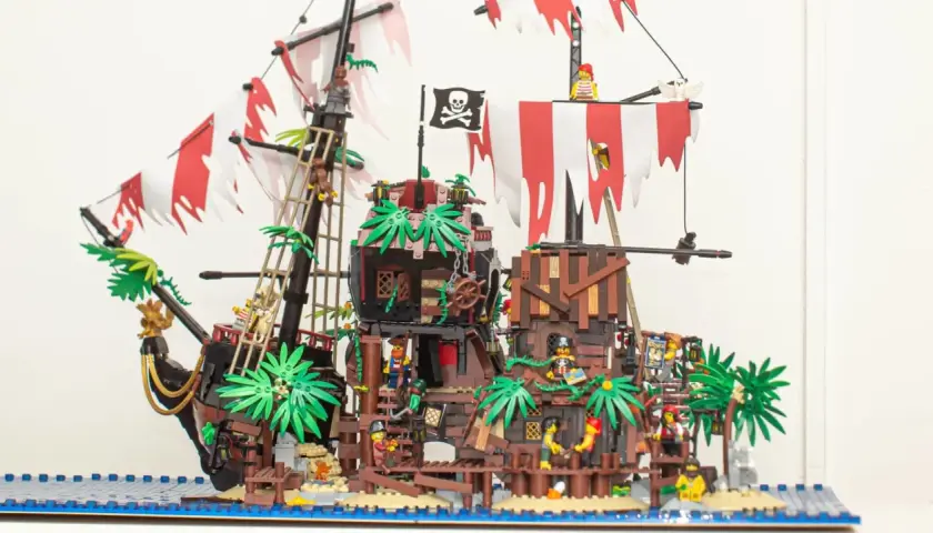 Ein detailreiches Lego Pirates MOC mit Piraten, Palmen und einem Schiff auf dem Wasser.
