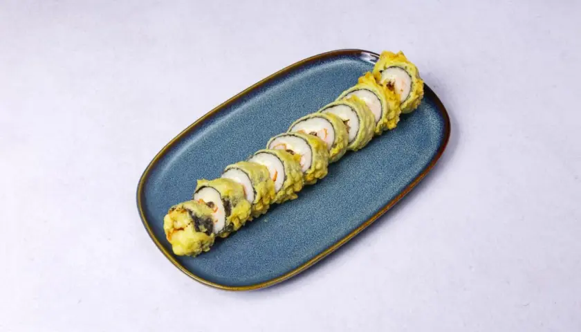 Chrupiące rolki sushi tempura z krewetkami na niebieskim talerzu.