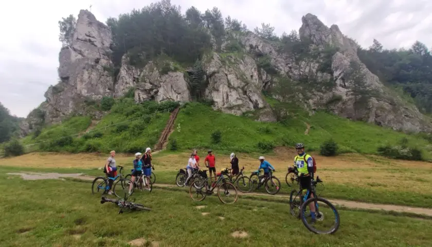Grupa rowerzystów na tle skalnych ostańców. Jura Krakowsko-Częstochowska rowerem to wspaniała przygoda.