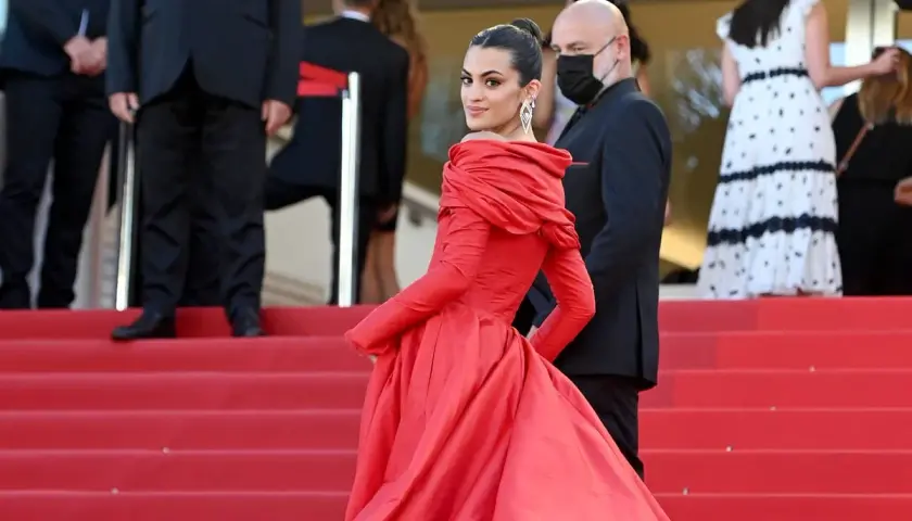 Una mujer luce un espectacular vestido rojo en la alfombra, demostrando cómo combinar un vestido rojo con elegancia y glamour.