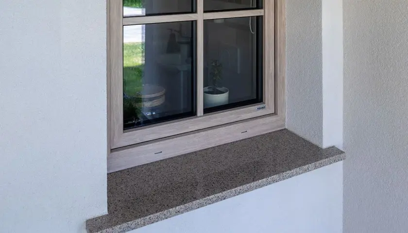 Kamienny parapet zewnętrzny wystaje ok. 5 cm, chroniąc elewację. Idealna proporcja, by wiedzieć, ile powinien wystawać parapet zewnętrzny.