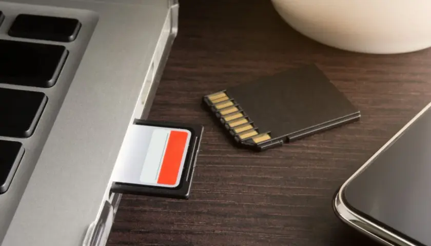 SD-Karte im Laptop-Slot, daneben eine weitere Karte und ein Smartphone. Die SD-Karte im Handy wird nicht erkannt.