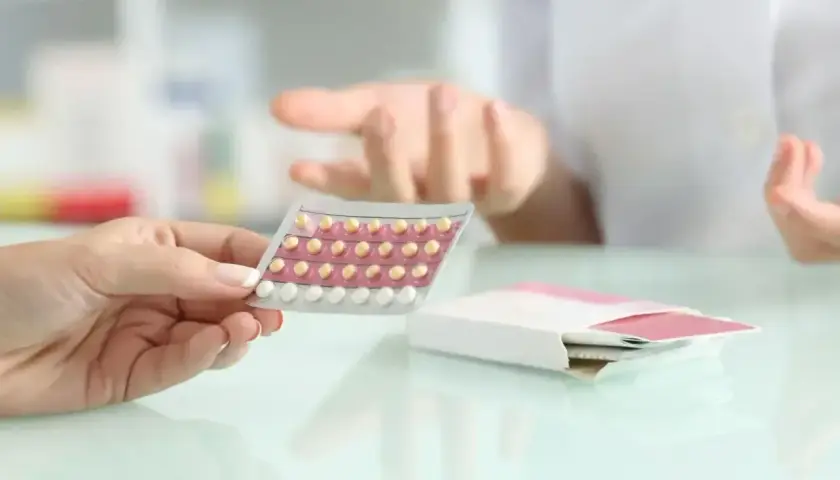 Dłoń trzyma blister tabletek antykoncepcyjnych. Farmaceuta wyjaśnia, bibloc na co.