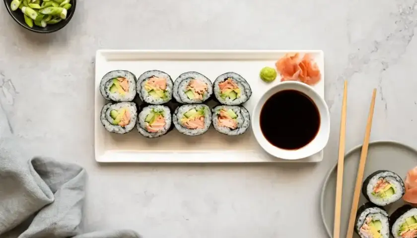 Smaczne hosomaki z łososiem i awokado, podane z sosem sojowym i wasabi.