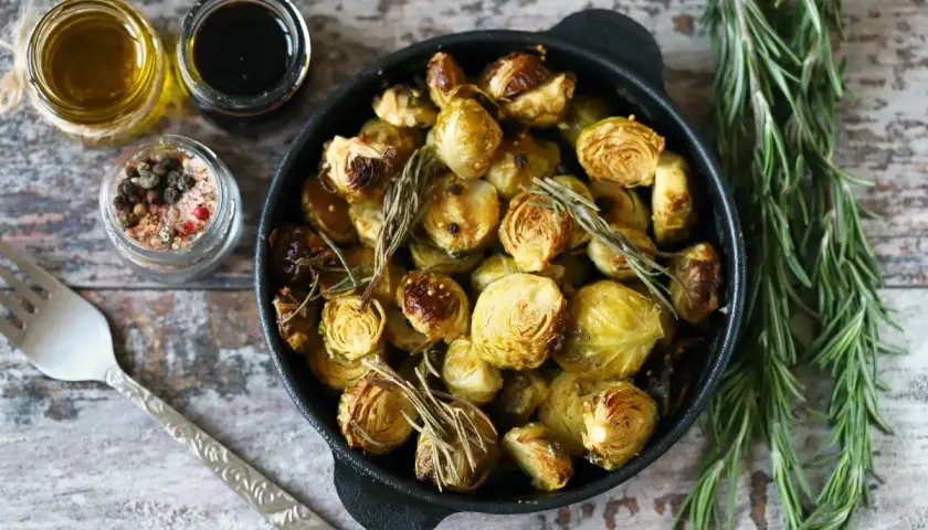 Cavoletti di Bruxelles arrostiti in padella con rosmarino, accompagnati da olio, aceto balsamico e sale aromatizzato.