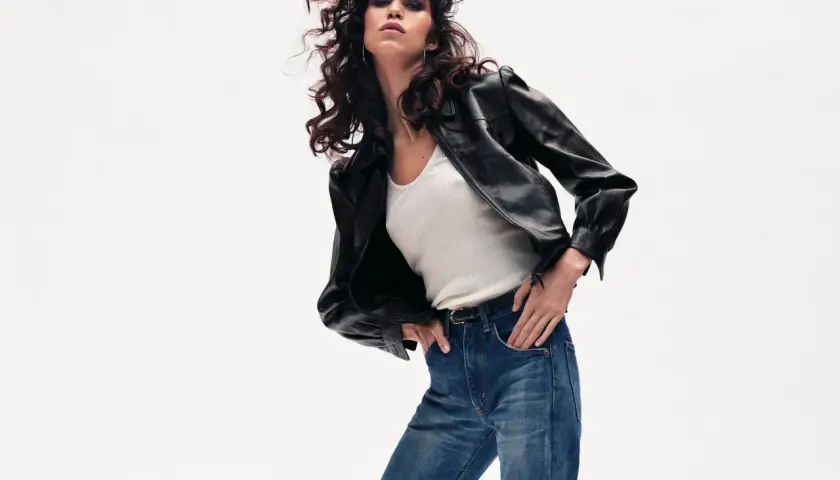 Une femme rock'n'roll porte un jean straight. Ce modèle flatte toutes les morphologies, créant une silhouette équilibrée et tendance.
