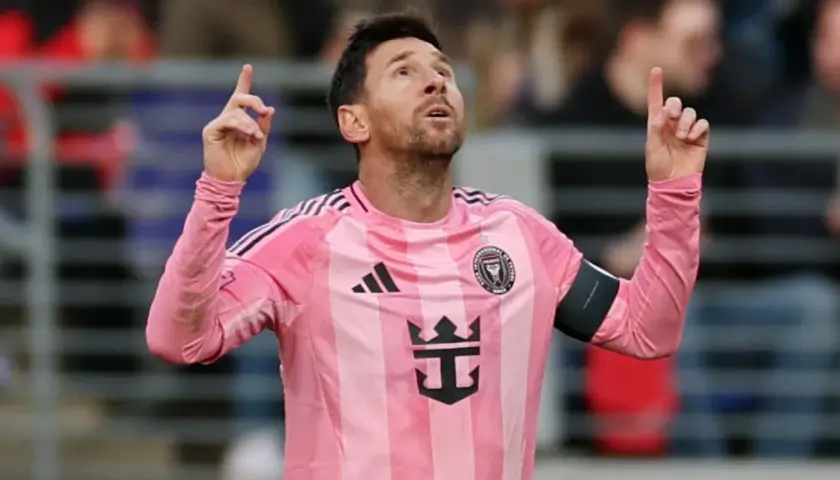 Piłkarz Lionel Messi w różowej koszulce Interu Miami, z uniesionymi palcami, jakby świętował kolejne bramki.