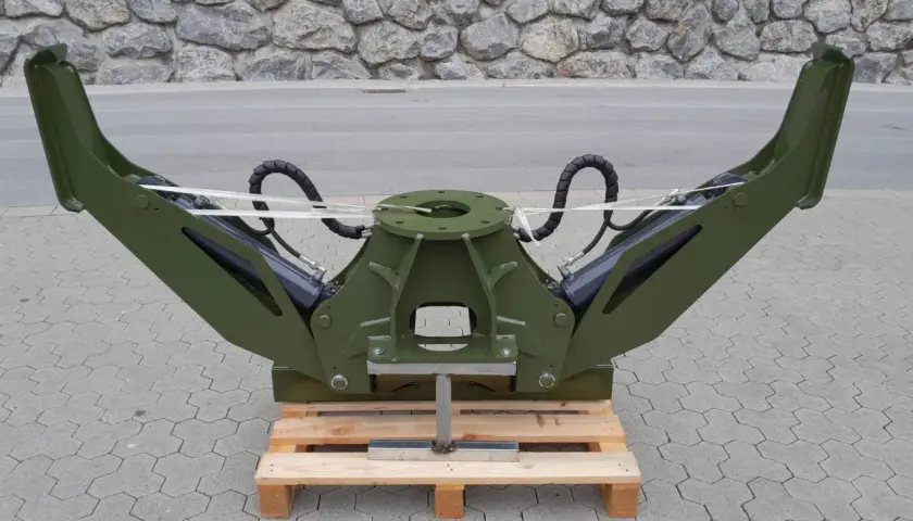 Grüner Forstkran-Greifer mit hydraulischen Armen, bereit für den Einsatz als Forstkran-Abstützung.