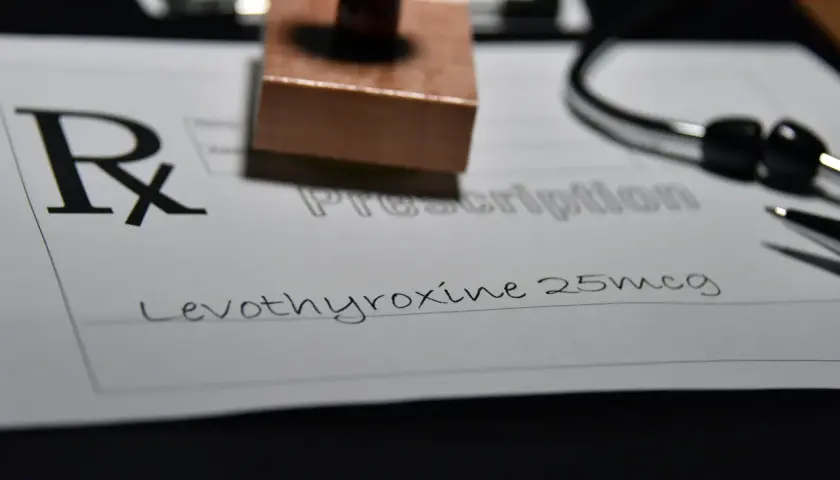 Recept na leki, na którym widnieje "Levothyroxine 25mcg". Obok stetoskop i pieczątka.