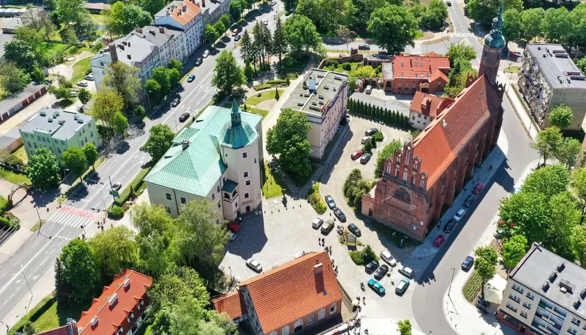 Słupsk atrakcje na weekend: zamek Książąt Pomorskich i kościół Mariacki z lotu ptaka. Zielone dachy i czerwona cegła tworzą malowniczy widok.