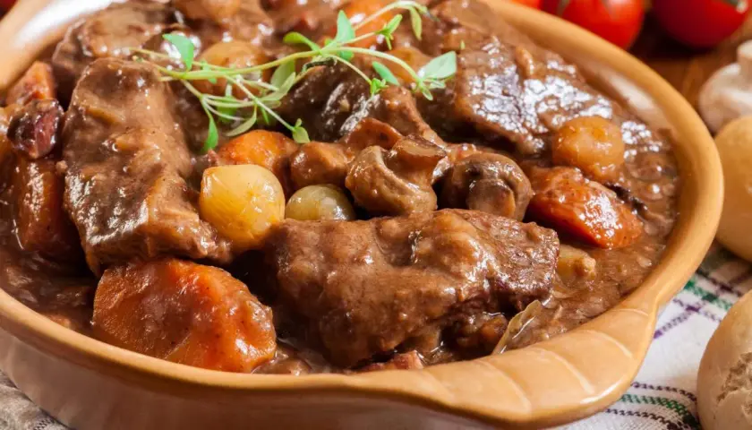 Gulasz wołowy z pieczarkami i cebulką, idealny przykład, jak przyrządzać wołowinę. Aromatyczne danie w glinianej misie.