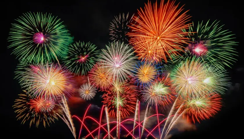 Ein farbenprächtiges Feuerwerk erhellt den Nachthimmel, wie es typisch für Silvester in Deutschland ist.