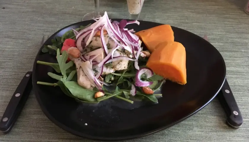 En tallrik med ceviche, sötpotatis och grönsaker. Fisken är marinerad i leche de tigre, en syrlig och smakrik citrusmarinad.