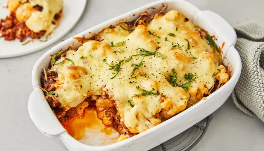 Herzhafter Blumenkohlauflauf mit Hackfleisch, überbacken mit geschmolzenem Käse und garniert mit frischen Kräutern. Ein köstliches Gericht, das Lust auf mehr macht.