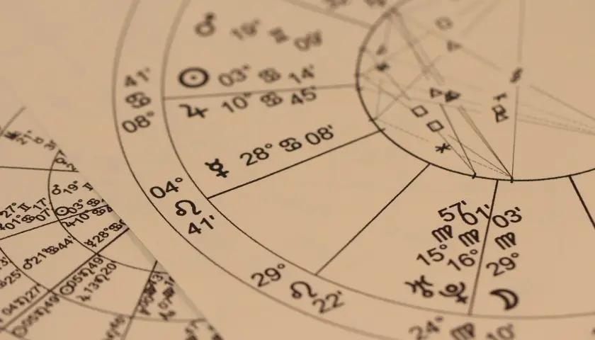 Zbliżenie na papier z wykresem astrologicznym, symbolami i liczbami. Może to być horoskop anielski na jutro.