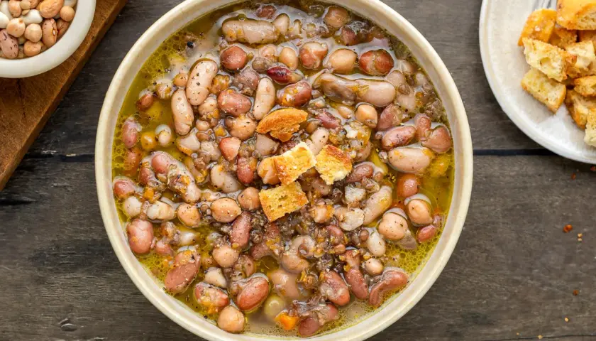 Una ciotola fumante di zuppa di legumi, ricca e saporita, con crostini dorati.