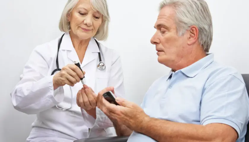 Diabetolog bada poziom cukru we krwi pacjenta.