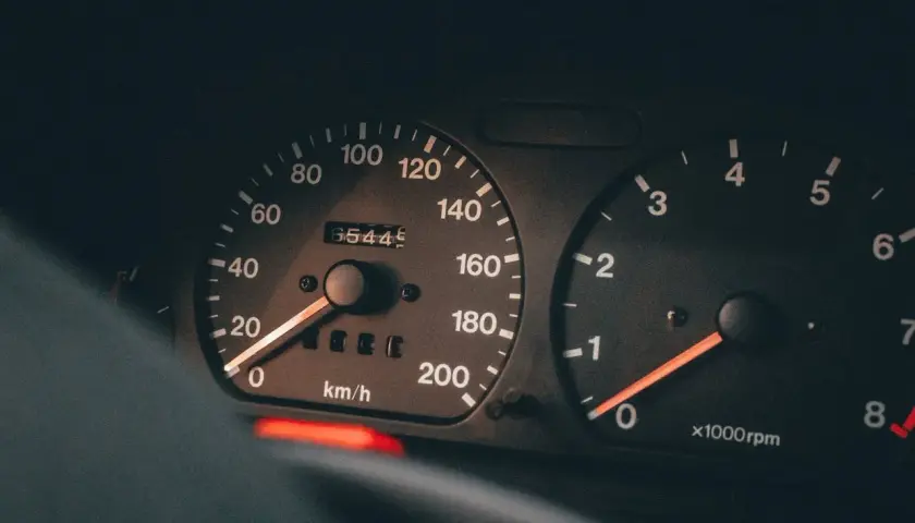 Zbliżenie na deskę rozdzielczą: prędkościomierz pokazuje 65445 km, a obrotomierz wskazuje niskie obroty, idealne dla diesla.
