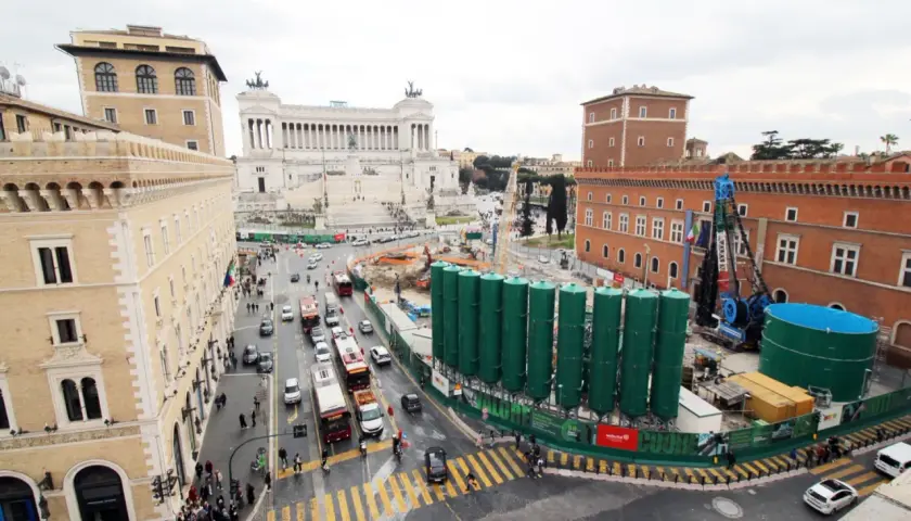 Vista aerea di Roma con il Vittoriano sullo sfondo e lavori in corso. Per capire come arrivare a Piazza Venezia, osserva il traffico e i palazzi storici.
