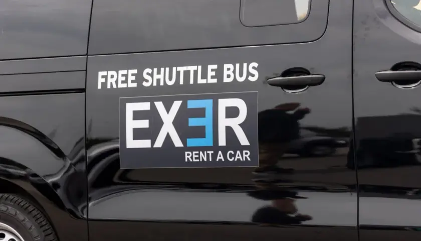 Black shuttle bus with "EXER RENT A CAR" logo. Considering whether to rent a car in Athens? This shuttle might be a good option.