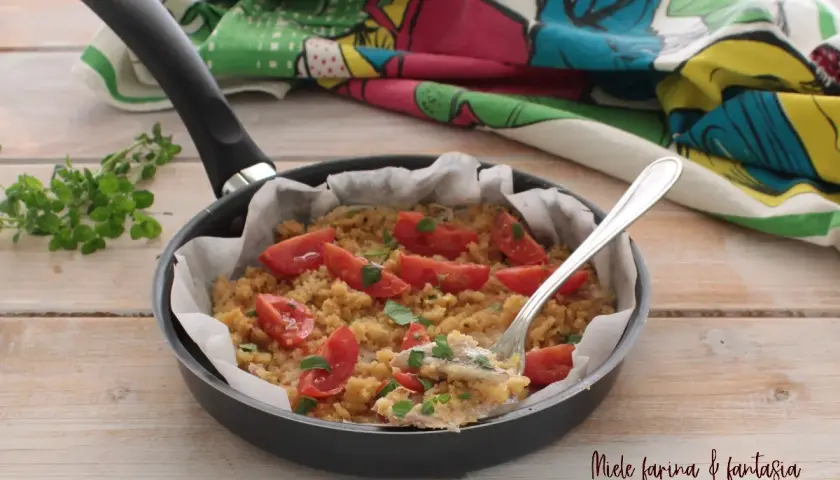 Alici gratinate in padella con pomodorini e pangrattato, un piatto semplice e gustoso.