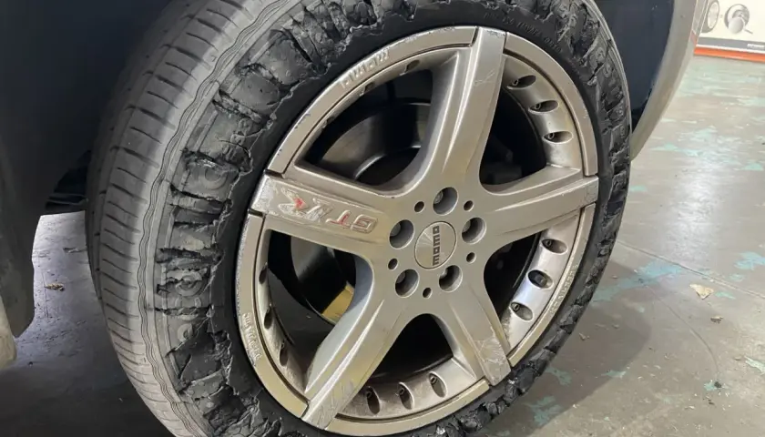 Rueda de coche con el lateral destrozado. Así puedes saber si una rueda está pinchada: busca grietas o desgarros.