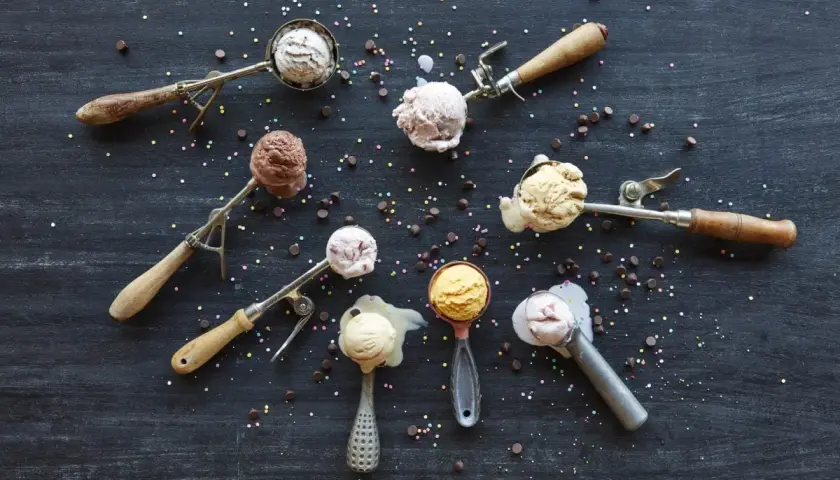 Verschiedene Eissorten in Eislöffeln, bereit zum Servieren. Perfekt, um eis selber machen zu wollen! Bunt bestreut mit Schokostückchen und Streuseln.