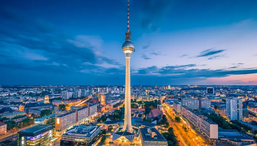 Fernsehturm reser sig över Berlins silhuett i skymningen. En perfekt vy för din berlin reseguide.