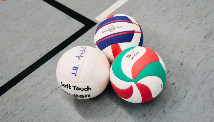 Trzy piłki siatkowe: biała z napisem "Soft Touch", biało-niebiesko-czerwona z napisem "Beachvolleyball Camp" i biało-zielono-czerwona Molten.