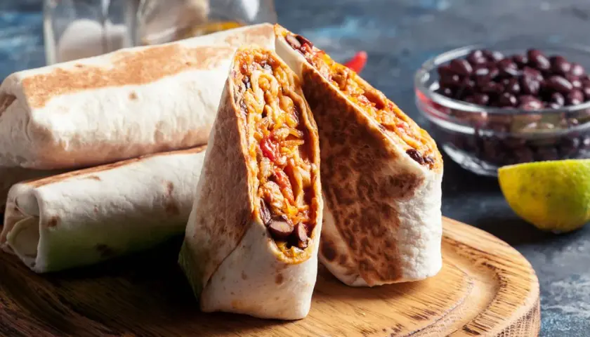 Fertige Burritos zum Einfrieren: Gestapelt und aufgeschnitten, zeigen sie eine Füllung aus Bohnen, Reis und Gemüse.