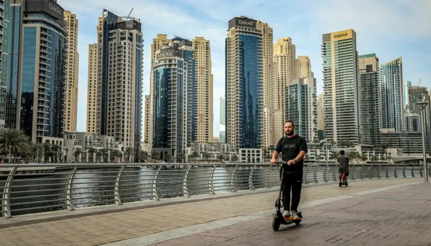 Mężczyzna na hulajnodze w Dubaju, wśród drapaczy chmur. Czy to początek afery dubajskiej?