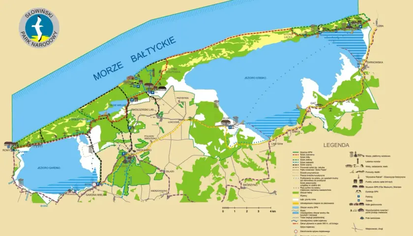Mapa turystyczna Słowińskiego Parku Narodowego z zaznaczonymi szlakami, jeziorami, wydmami i miejscowościami.