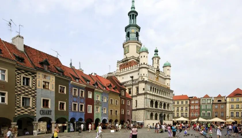 Kolorowy Rynek w Poznaniu, jedno z miejsc, które pokazują, jakie miasta warto zwiedzić w Polsce. Tętniący życiem plac z ratuszem i kamieniczkami.