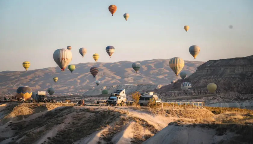 Balony unoszą się nad skalistym krajobrazem Kapadocji w Turcji, tworząc magiczny widok.