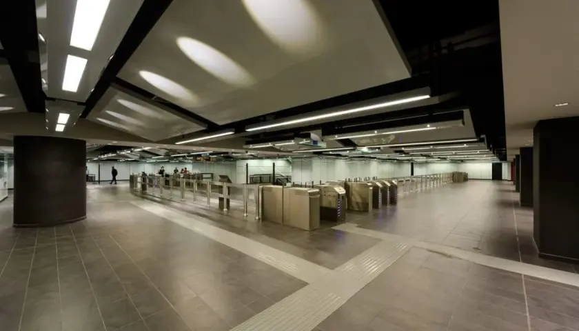 Ingresso moderno della metro Mirti con tornelli e illuminazione a soffitto.