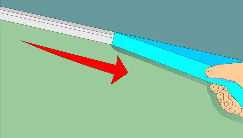 Applicazione di nastro adesivo blu per definire come fare bordo tra soffitto e parete. Freccia rossa indica la direzione.