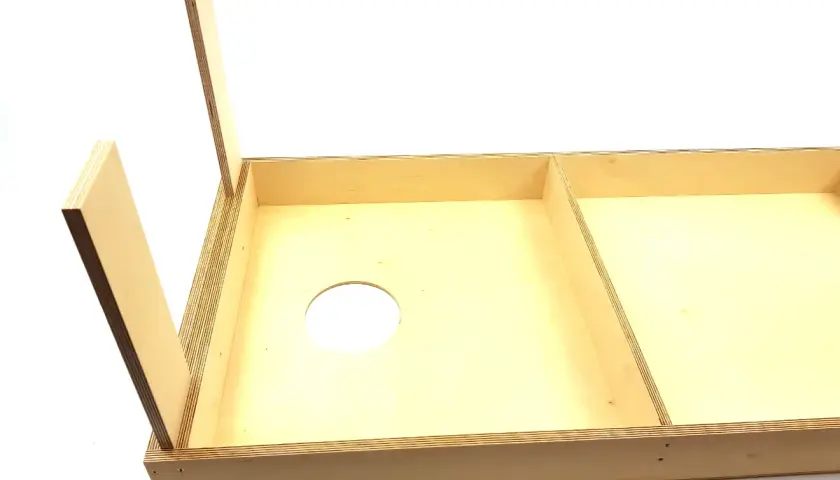 Holzplatte mit Loch für Cornhole selber bauen. Zwei aufgestellte Holzbeine deuten auf den Beginn des Projekts hin.