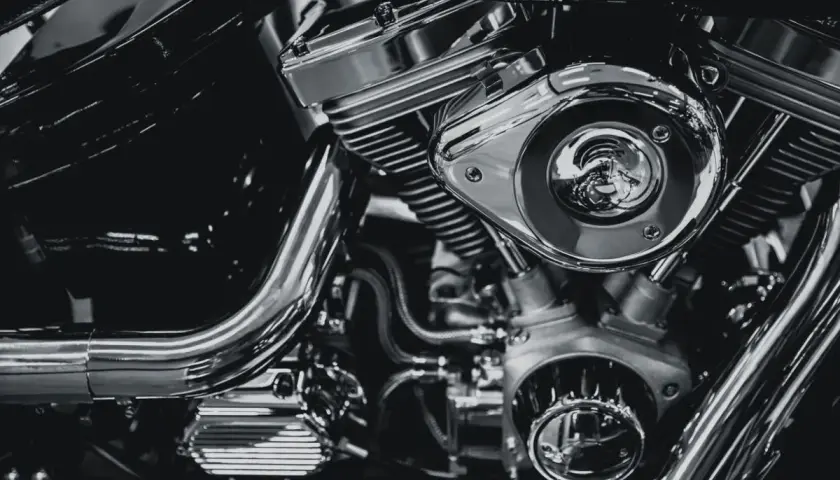Detalle de un motor de motocicleta cromado, mostrando el sistema de alimentación y sus componentes.