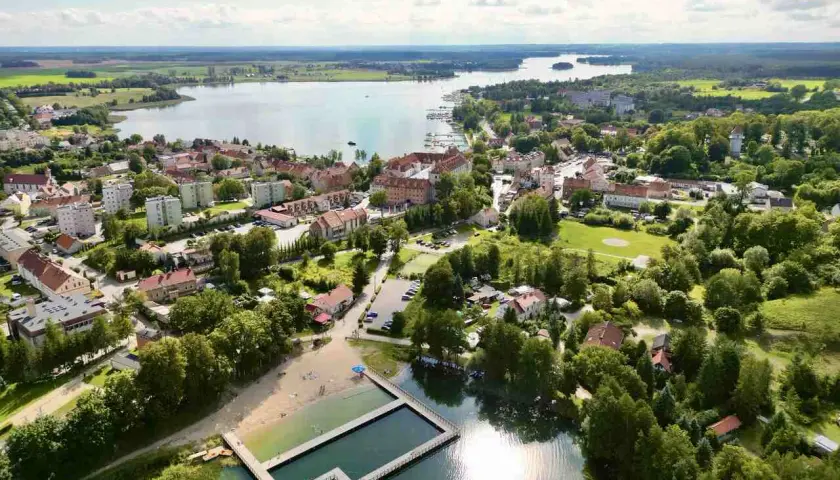 Malownicze miasteczko nad jeziorem, z plażą i basenem kąpielowym. Ryn oferuje piękne widoki i relaks.