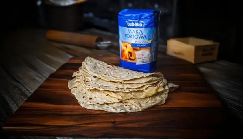 Stos świeżo upieczonych placków lawasz, obok mąka tortowa Lubella. Idealne do wrapów i jako dodatek do dań.