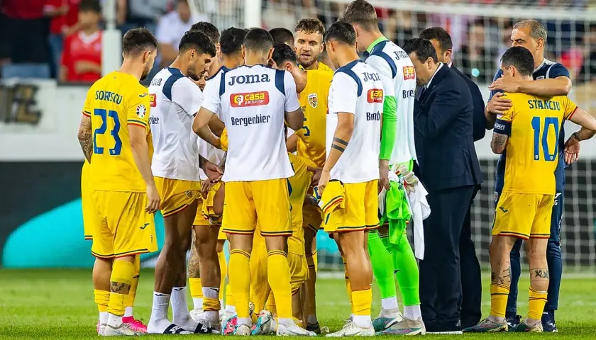 Piłkarze Rumunii w żółtych strojach, w tym Sorișcu (23) i Stanciu (10), zebrani na boisku. Może to być mecz z Ukrainą.