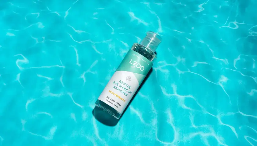 L300 Gentle Eye Make-Up Remover, en effektiv sminkborttagning utan olja, vilar på en bakgrund av turkost vatten.