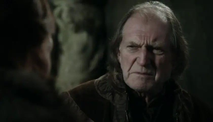 David Bradley w filmach i serialach, z charakterystycznym zmarszczonym czołem, w rozmowie z kimś.
