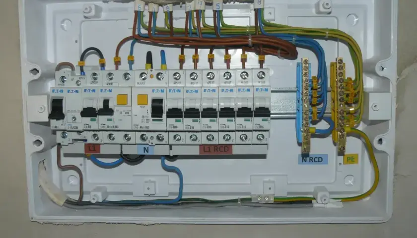 Instalacja elektryczna z bezpiecznikami B16. Widoczne wyłączniki nadprądowe, RCD, listwy zaciskowe N i PE.