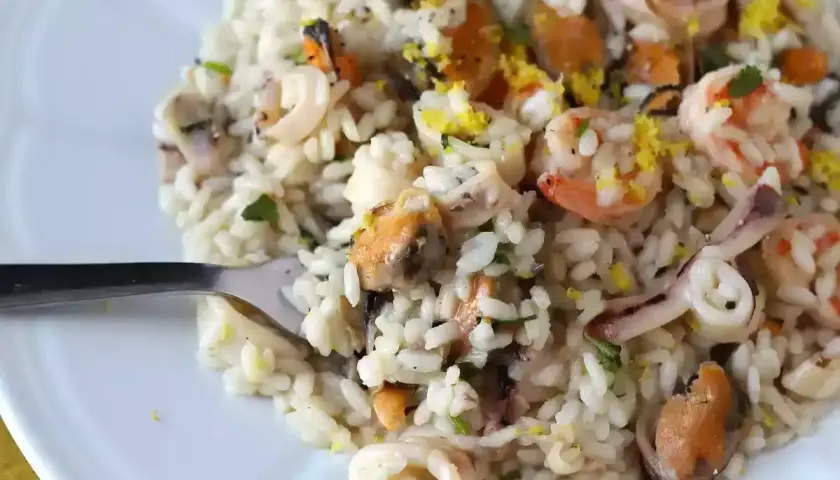 Un délicieux risotto fruits de mer crémeux, garni de crevettes, moules et calamars, avec une touche de zeste de citron.