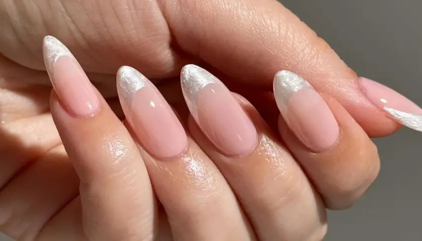 Delikatne, różowe paznokcie w stylu princess nails french z błyszczącym, srebrnym wykończeniem na końcówkach.